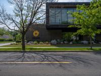 a building with a logo painted on the side near a street that has a sidewalk next to it