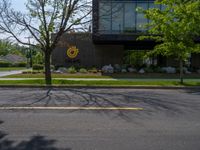 a building with a logo painted on the side near a street that has a sidewalk next to it