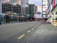 the empty street with buildings and a fire hydrant on one side and a stoplight on the other side