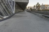 a sidewalk near the large building with several windows and people walking around outside of it