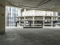 a concrete bench in an outdoor parking garage with lots of windows in the background,