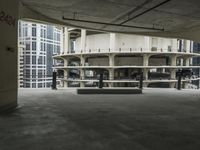 a concrete bench in an outdoor parking garage with lots of windows in the background,