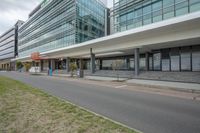 an office building on the corner with grassy field in front of it in an urban area