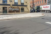 two trucks parked in front of a grocery store on the side of a street in the middle of town