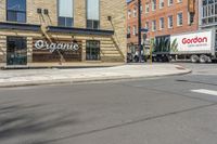 two trucks parked in front of a grocery store on the side of a street in the middle of town