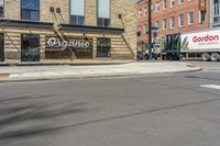 two trucks parked in front of a grocery store on the side of a street in the middle of town