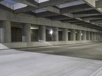 an empty parking garage with no people in it at night time time with only one stop sign