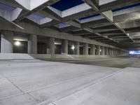 an empty parking garage with no people in it at night time time with only one stop sign
