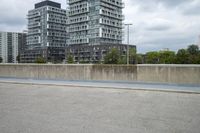 the gray building is built along the street side with high buildings in the background for urban design