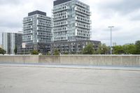 the gray building is built along the street side with high buildings in the background for urban design