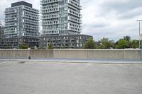the gray building is built along the street side with high buildings in the background for urban design