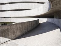 this building is designed like a spiral staircase with concrete surfaces, and the walls are lined in arches