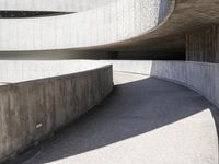 this building is designed like a spiral staircase with concrete surfaces, and the walls are lined in arches