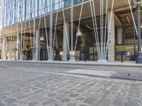 the sidewalk of a street in front of an office building with lots of glass on it