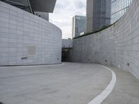 a skateboarder rides through a parking lot in front of buildings in the city