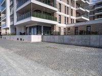 an empty concrete parking lot next to some buildings on the hillside side with several windows