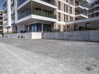 an empty concrete parking lot next to some buildings on the hillside side with several windows