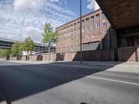a street under a bridge that is over some cars going under it's bridge