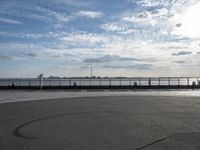 a view of a body of water near the boardwalk in front of some buildings and an iron fence