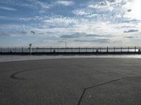 a view of a body of water near the boardwalk in front of some buildings and an iron fence