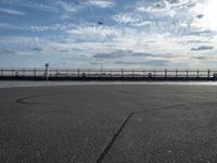 a view of a body of water near the boardwalk in front of some buildings and an iron fence