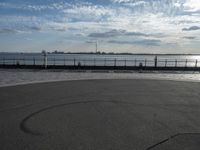 a view of a body of water near the boardwalk in front of some buildings and an iron fence