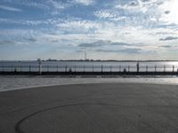 a view of a body of water near the boardwalk in front of some buildings and an iron fence