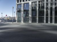 a person on a skateboard rides down a street in front of a building with windows