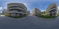 a spherical fish eye photograph of an apartment complex and parking lot, taken from a video camera