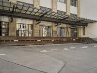 an empty building with signs on the street and people on bikes in traffic passing by