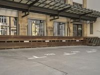 an empty building with signs on the street and people on bikes in traffic passing by