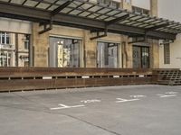 an empty building with signs on the street and people on bikes in traffic passing by