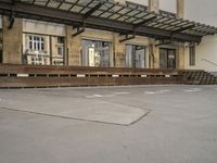 an empty building with signs on the street and people on bikes in traffic passing by