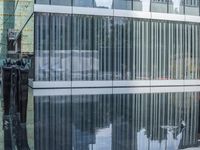 a black and white photo with the reflection of another statue outside of a building in front of it