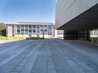 an empty concrete pavement with building in the background, outside view, from sidewalk level