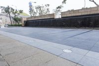 black and grey tiles are next to a large wall with a sign on it and trees in the background