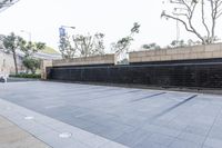 black and grey tiles are next to a large wall with a sign on it and trees in the background