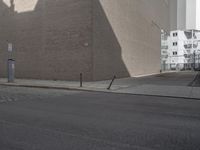 a large brown building in the middle of some buildings by a street corner and several parked cars