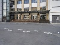 an empty building with signs on the street and people on bikes in traffic passing by