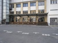 an empty building with signs on the street and people on bikes in traffic passing by