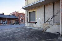 the building has stairs and windows by it's door on the sidewalk corner where it is