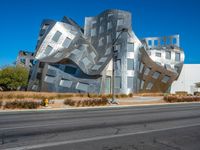 the building is clad in shiny silver tiles, it's located on a street corner