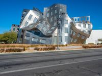 the building is clad in shiny silver tiles, it's located on a street corner