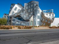 the building is clad in shiny silver tiles, it's located on a street corner