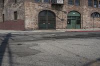 an empty street lined with a brick building and a small fire hydrant in front