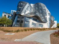 an office building made of metal with a circular design, sitting in a desert area