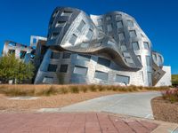 an office building made of metal with a circular design, sitting in a desert area