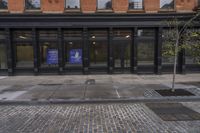 a sidewalk with two buildings in the background, and a sign on one of the buildings that says, ` we're open from 2pmercept '