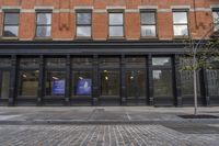 a sidewalk with two buildings in the background, and a sign on one of the buildings that says, ` we're open from 2pmercept '