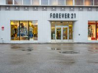 a store front with several small windows in an empty lot near a building with a sign for forever 21 on the window